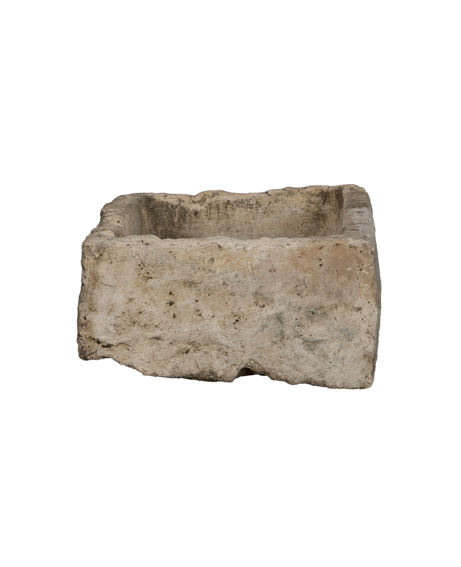 Vintage Indonesian limestone trough showcasing rough, weathered texture and natural imperfections from a side angle.
