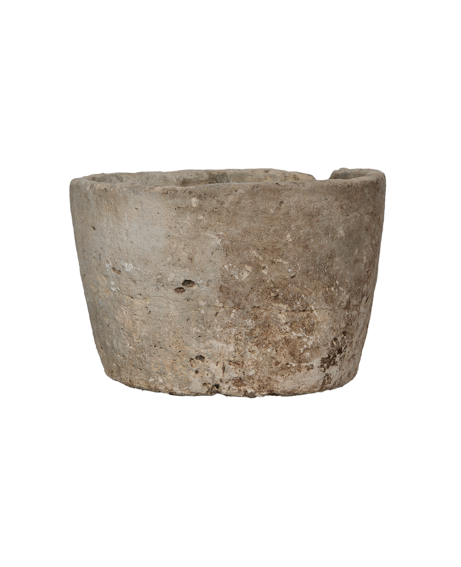 Round vintage limestone trough, close-up upper rim detail with weathered texture and chips.