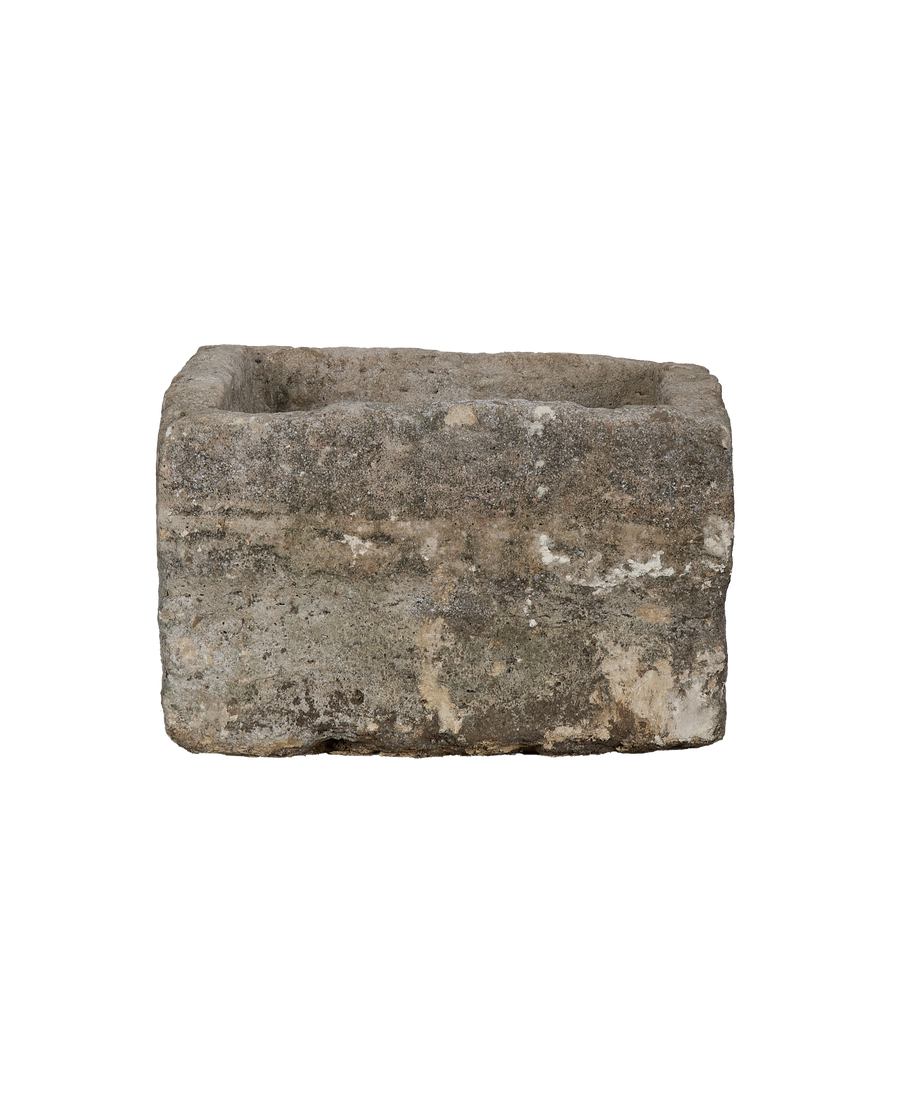 Vintage Indonesian rectangular limestone trough, close-up of rough weathered side texture.