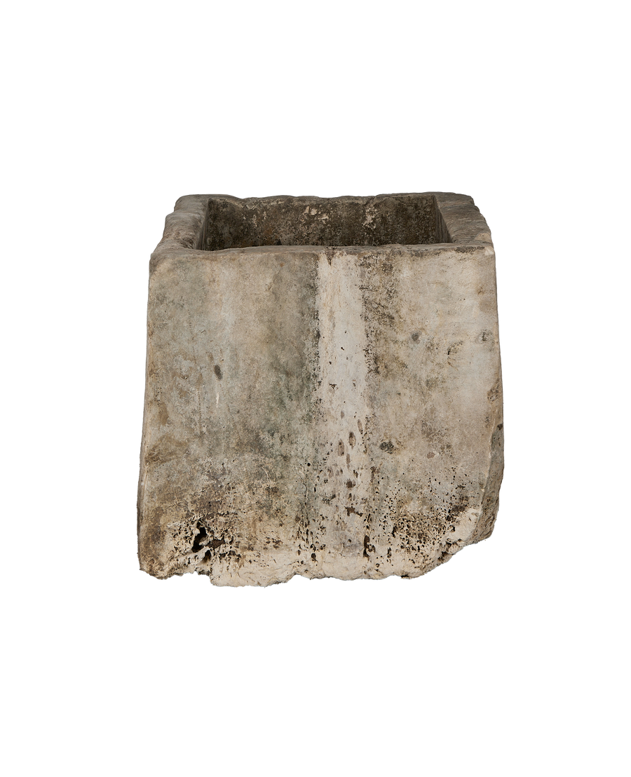 Vintage Indonesian limestone trough, showing a side view of weathered texture and aged patination.