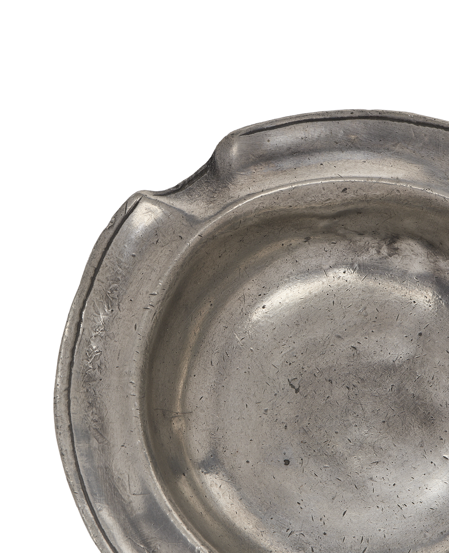 Vintage French pewter ashtray, close-up of intricate rim detail and worn metal texture.