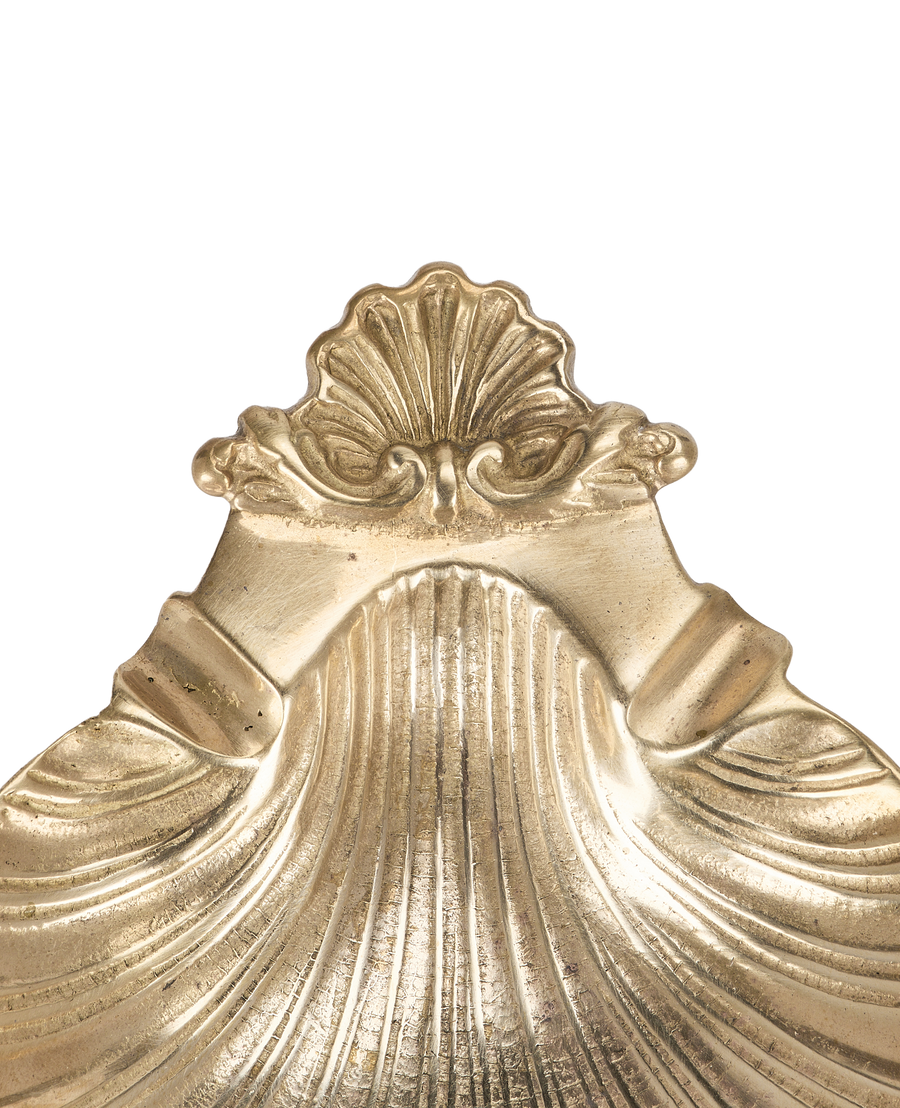Close-up of vintage French bronze shell vide poche's ornate scallop crest detail.