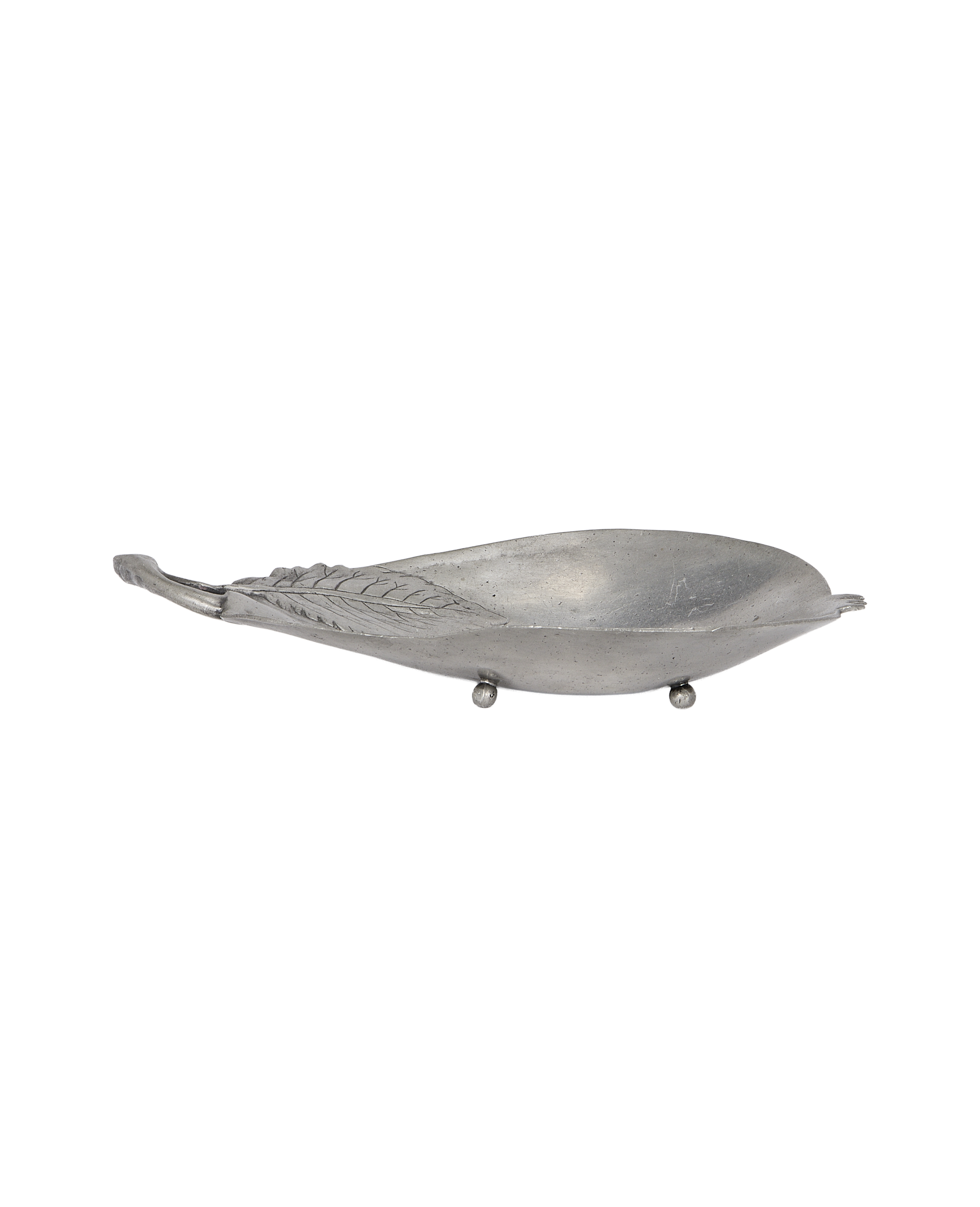 Vintage French pewter vide poche, pear shape with embossed leaf detail, angled view.