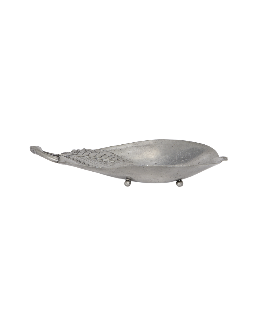 Vintage French pewter vide poche, pear shape with embossed leaf detail, angled view.