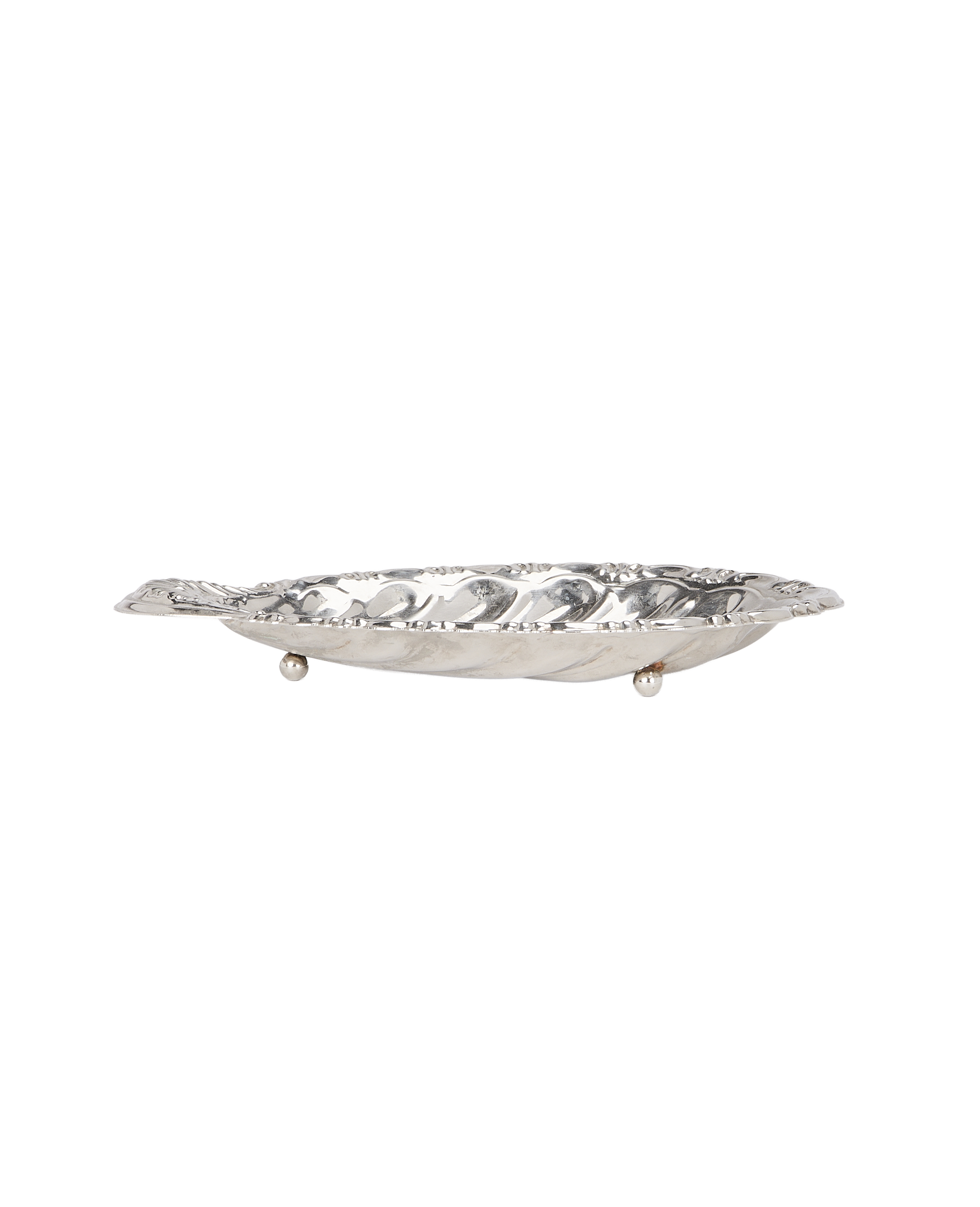 Vintage silver shell vide poche, elegant side view highlighting tripod feet.