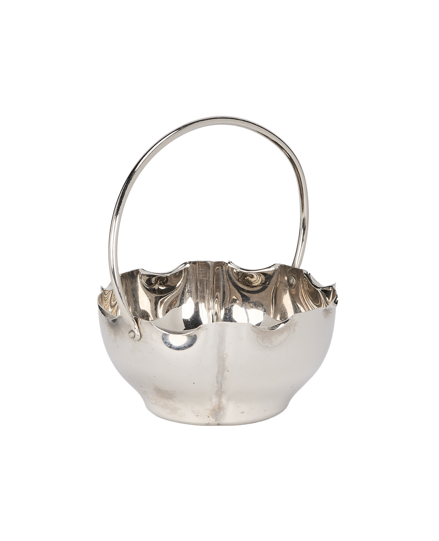 Vintage French silver-plated basket, showing fine patina, smooth handle connection, and wavy rim detail.