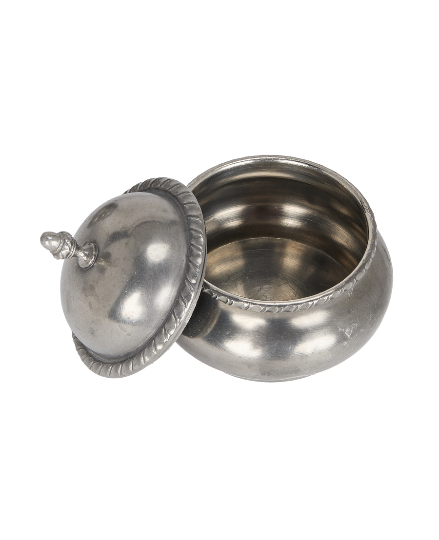 Vintage steel condiment pot with lid ajar, showing internal capacity and rope detail.