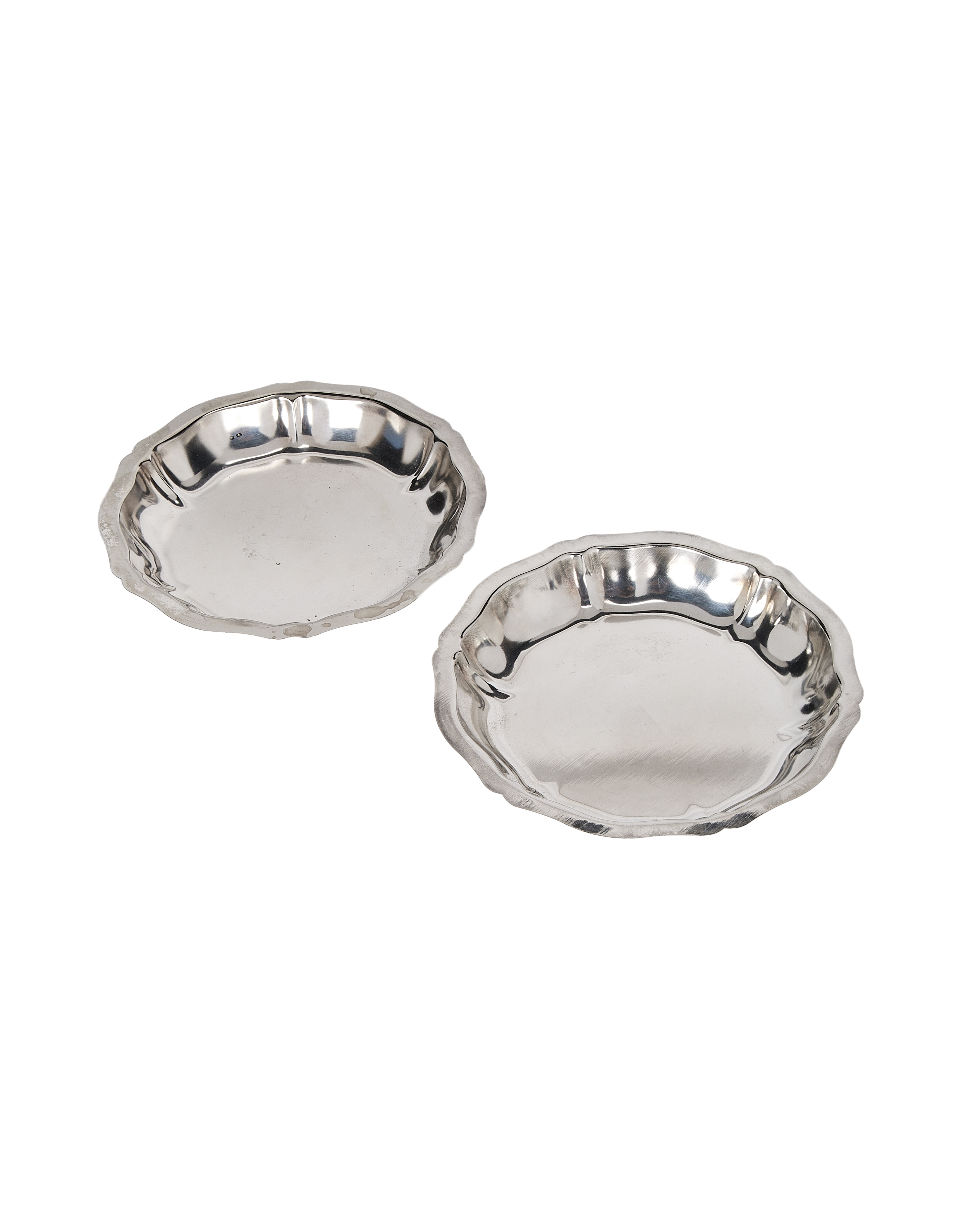 Two vintage silver-plated metal dishes with scalloped rims, angled top view, light wear.