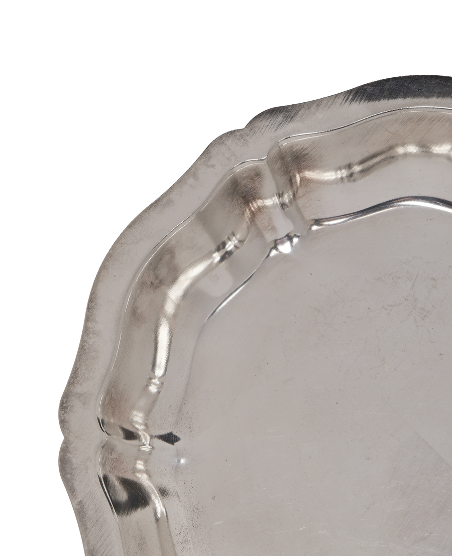 Vintage French metal dish, close-up of wavy crimped edge, showing aged silver finish.