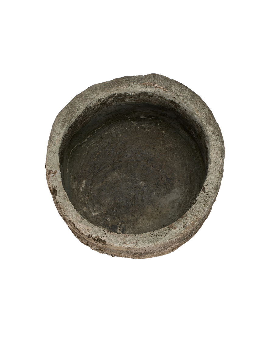 Vintage round limestone trough, top view emphasizing weathered texture and deep indentations.