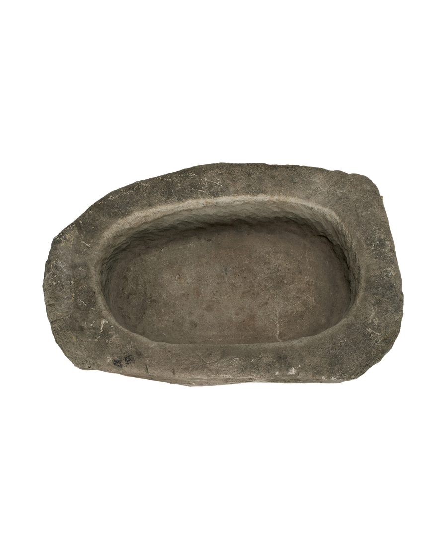 Vintage Indonesian oblong limestone trough, dark gray and textured, showing interior detail and worn rim.