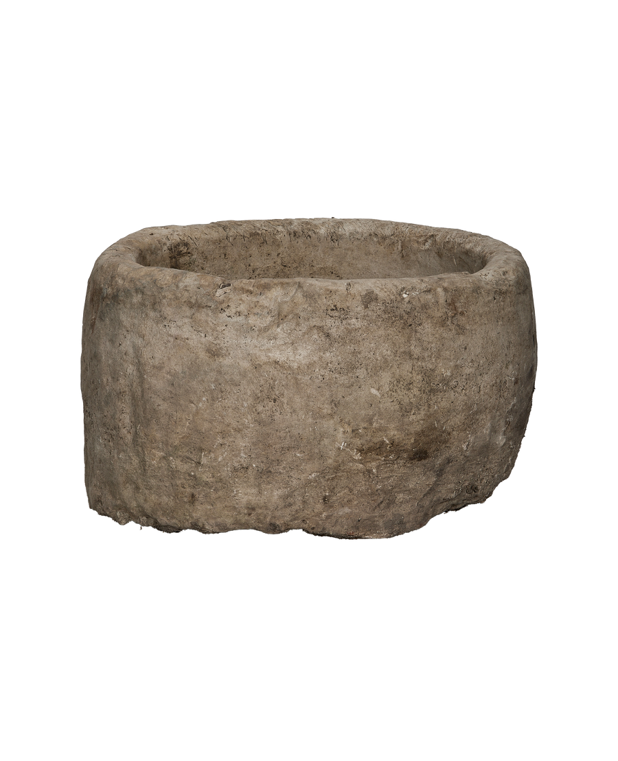 Vintage, round Indonesian limestone trough showing its textured, weathered exterior from the side.