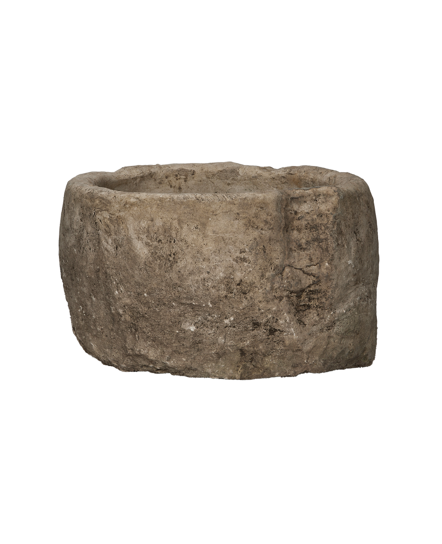 Vintage Indonesian limestone trough, round, showing detailed texture and weathered condition from side perspective.
