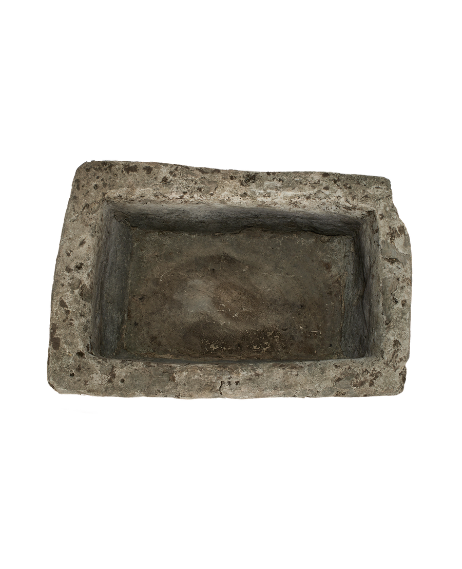 Vintage limestone trough, top-down view showing interior depth and rough texture.