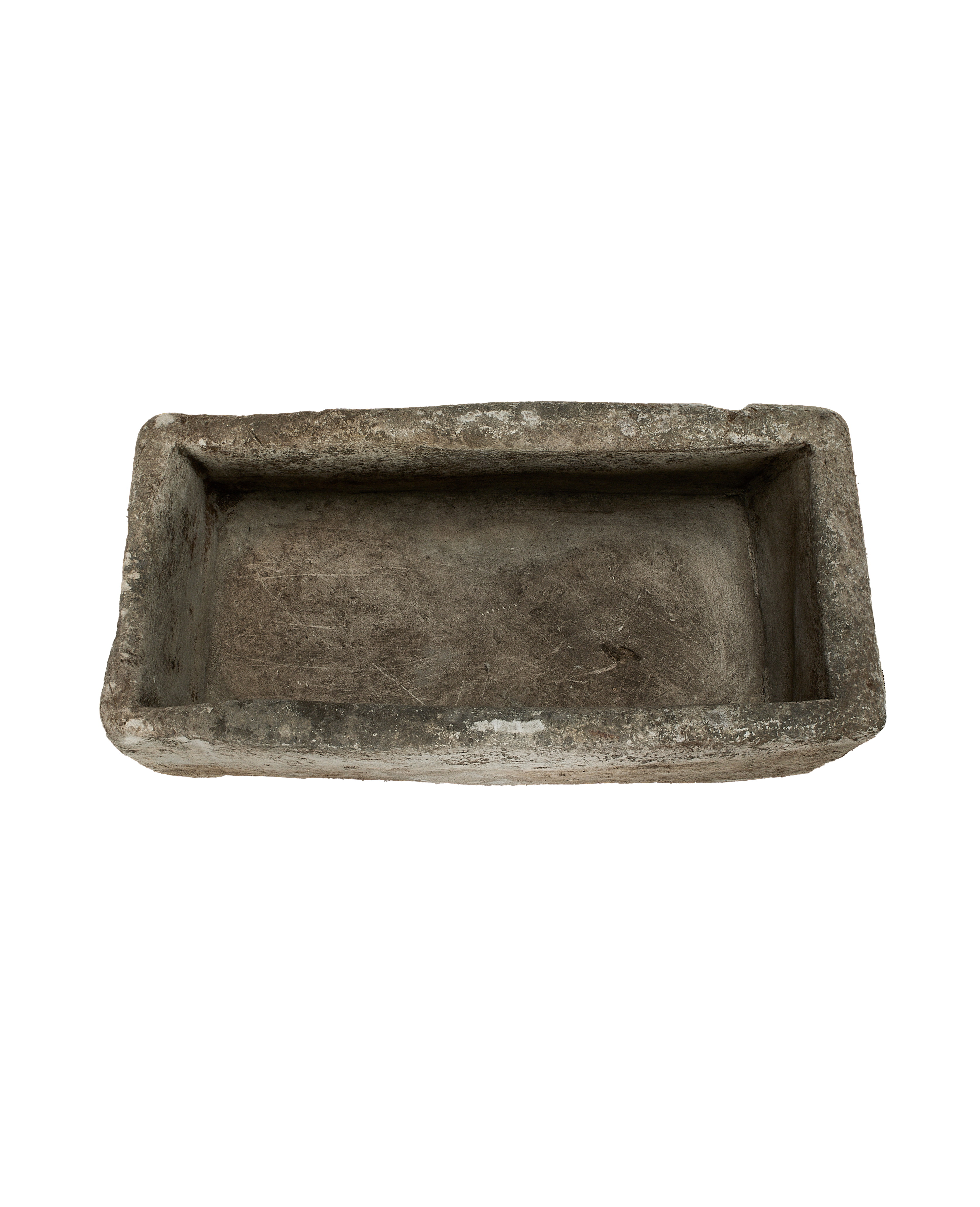 Vintage rectangular limestone trough, showing the interior base and chipped, weathered rim.