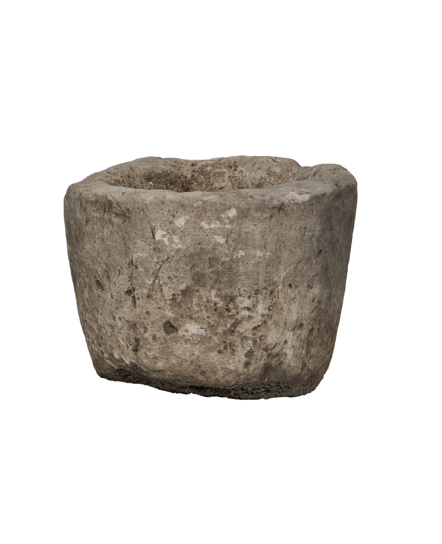 Vintage Indonesian limestone trough, showing rough, weathered texture and imperfections, side angle.