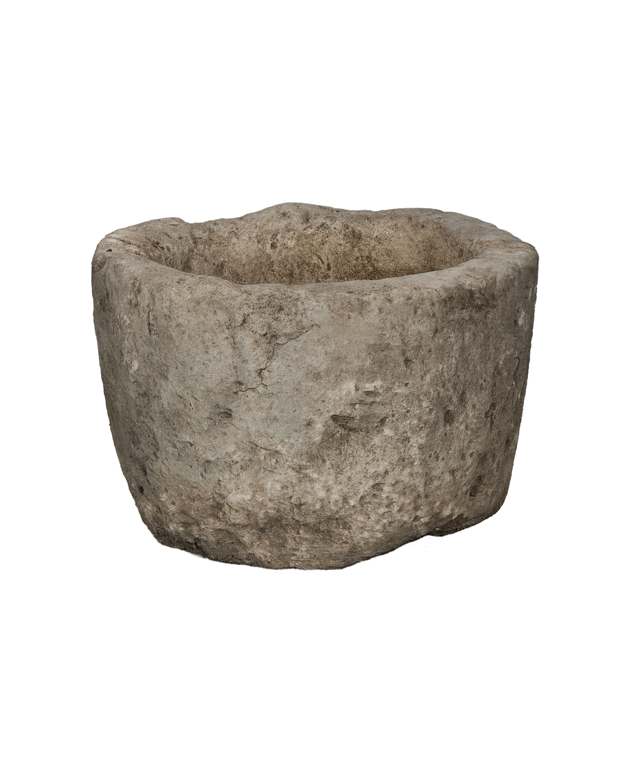 Vintage Indonesian round limestone trough, showing its rough, weathered exterior texture.