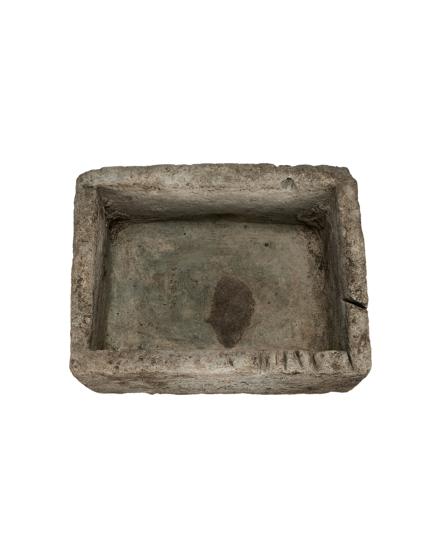 Vintage gray limestone trough from above, showcasing rough texture and weathered interior.