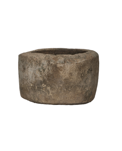 Vintage Indonesian round limestone trough, naturally weathered with textured surface, on black.