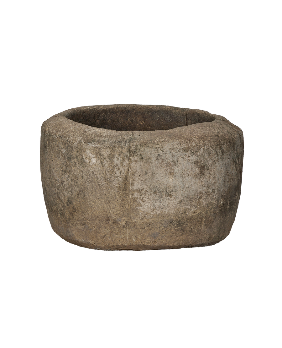 Vintage Indonesian round limestone trough, profile view revealing weathered texture and rustic charm.