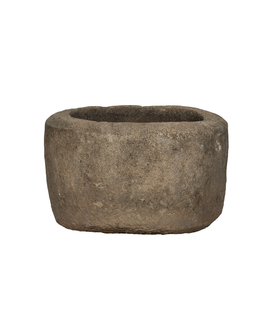 Vintage Indonesian round limestone trough, showing rough textured exterior and aged patina.
