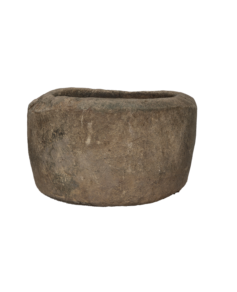 Vintage Indonesian round limestone trough, side profile showcasing textured, aged surface, and gently curved body.