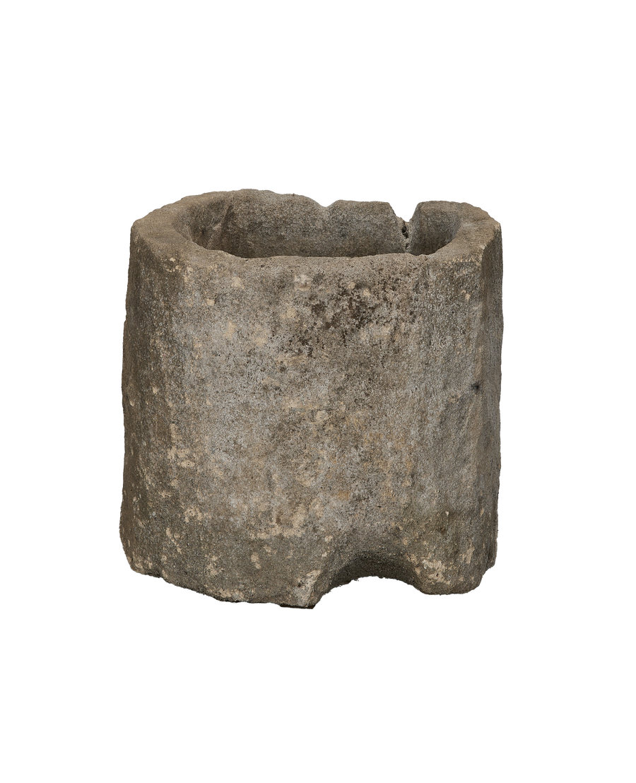 Vintage Indonesian limestone trough, showing a full, weathered cylindrical body with an oblong opening.