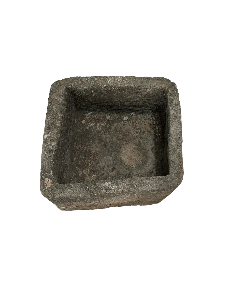 Vintage square limestone trough, top view showcasing weathered interior and rough stone edges.