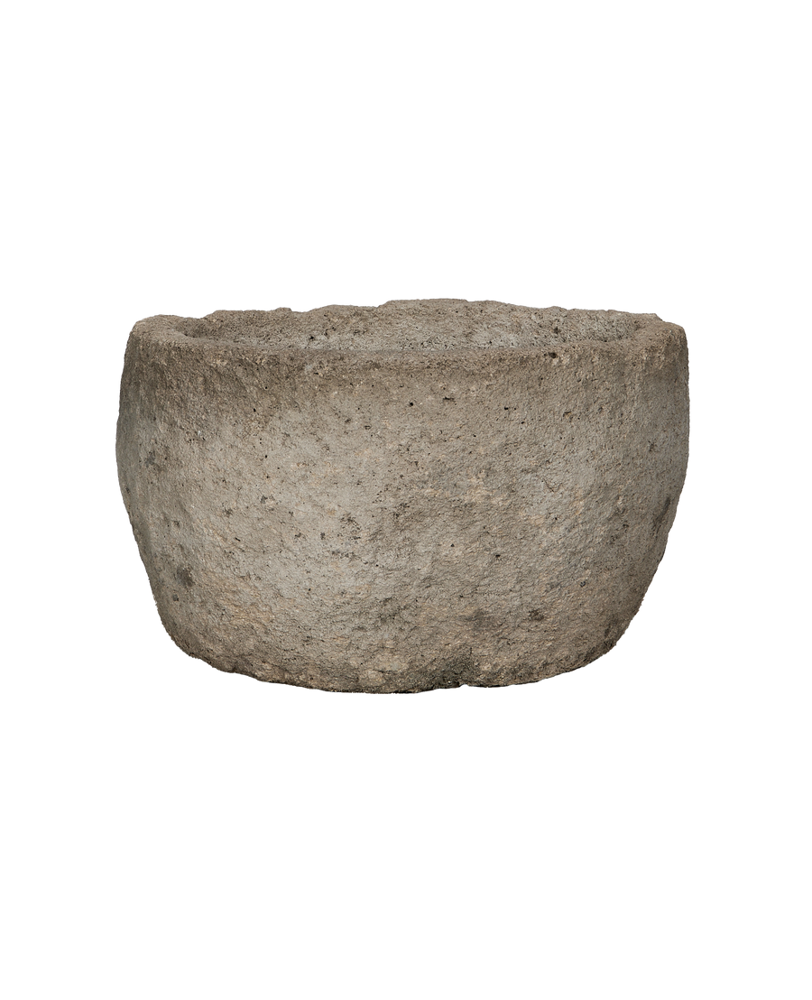 Vintage round Indonesian limestone trough, showing rough textured exterior and natural stone finish.