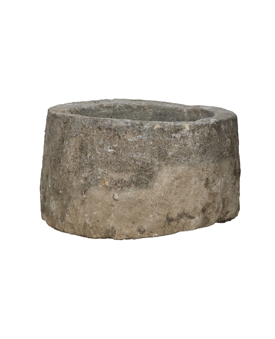 Vintage round limestone trough, lower angle showing weathered texture and natural imperfections.