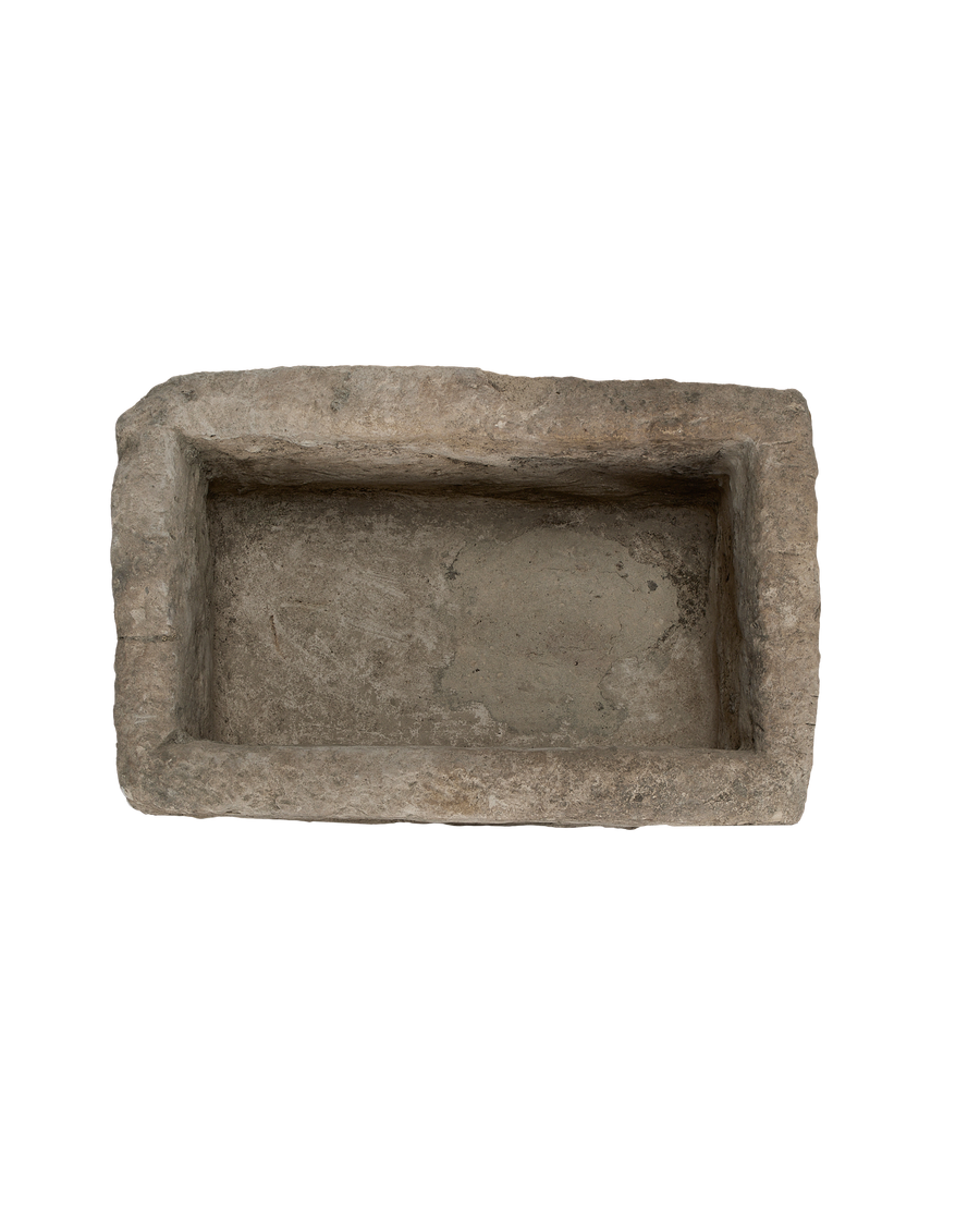 Vintage Indonesian limestone trough viewed top-down, highlighting weathered interior and irregular edges.