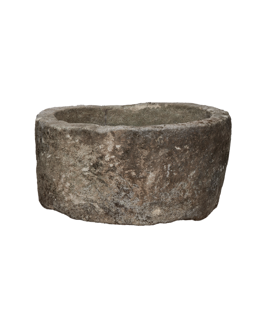 Vintage round limestone trough, side profile showcasing rough texture and natural patinas, Indonesian antique.