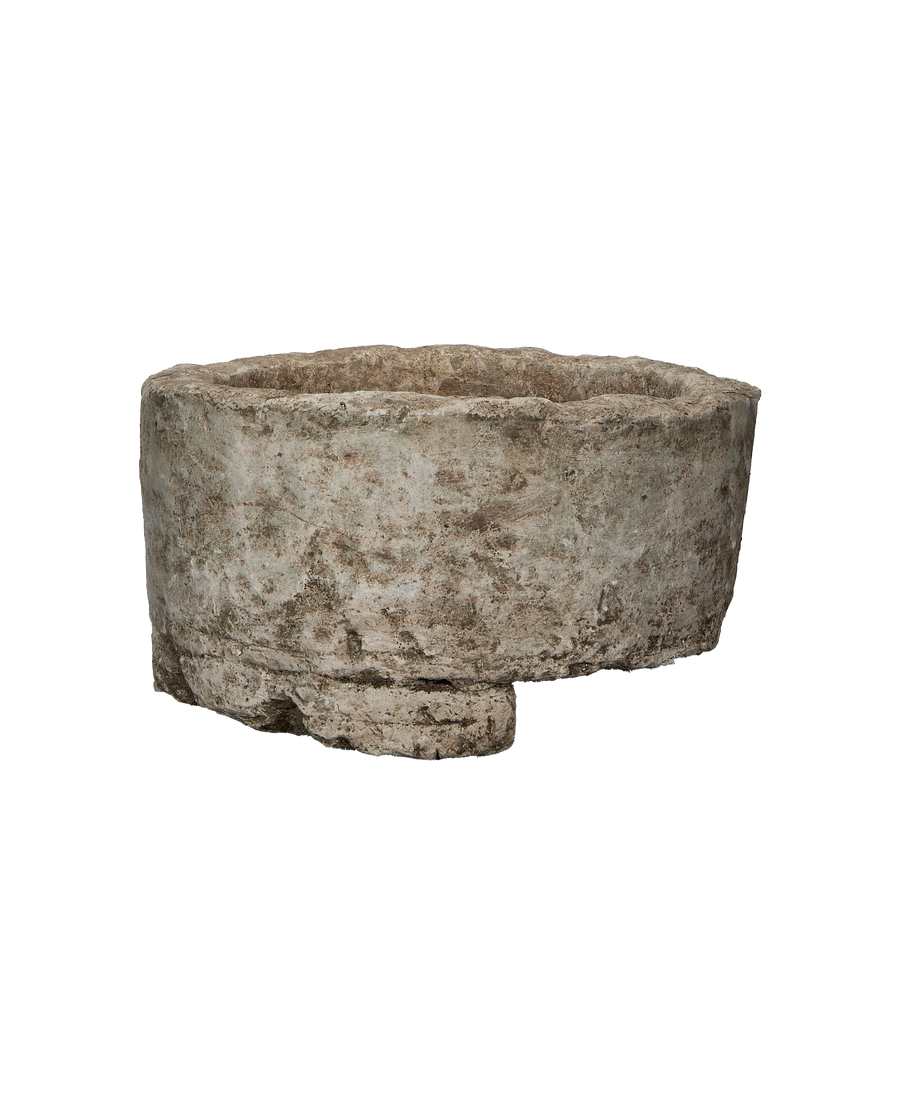 Vintage Indonesian round limestone trough, showing a cracked, weathered base and rough-hewn texture.