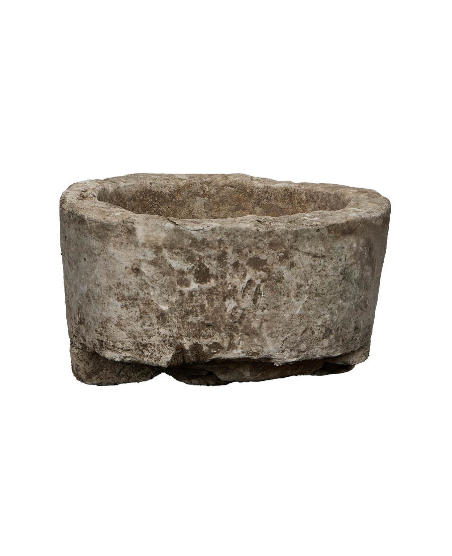 Vintage Indonesian brown limestone trough, weathered surface texture close-up, rugged base detail.