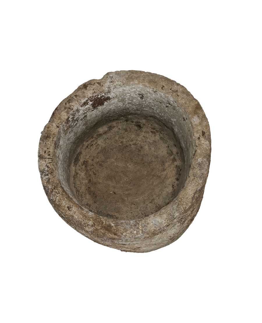 Vintage Indonesian round limestone trough, top view highlights weathered interior texture and age.