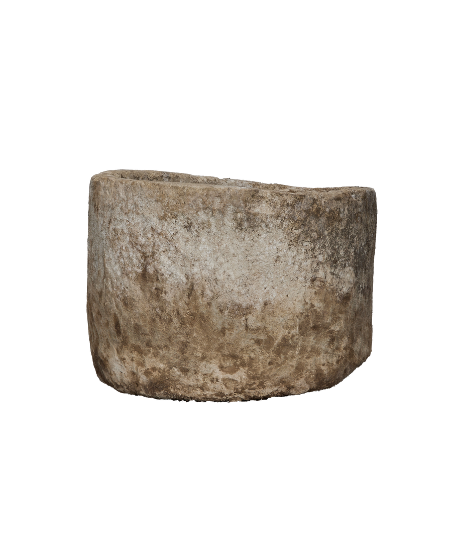Vintage Indonesian round limestone trough, showing a side view with weathered texture and patinated surface.