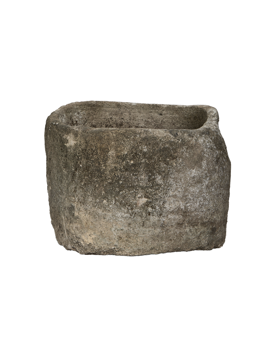 Vintage Indonesian limestone trough, close-up of rough, weathered texture and earthy patina.