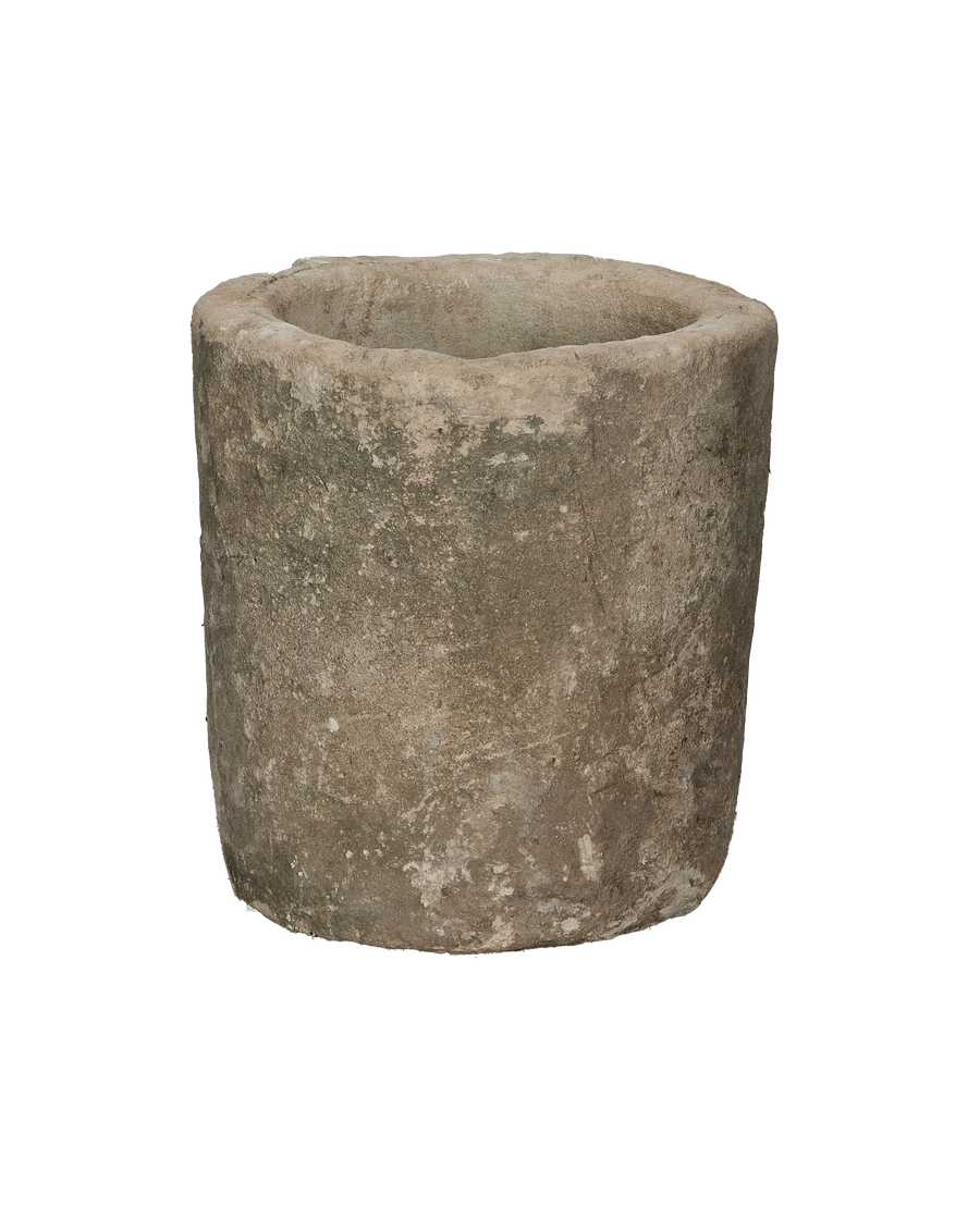 Vintage round Indonesian limestone trough showing weathered, textured exterior from a side angle.