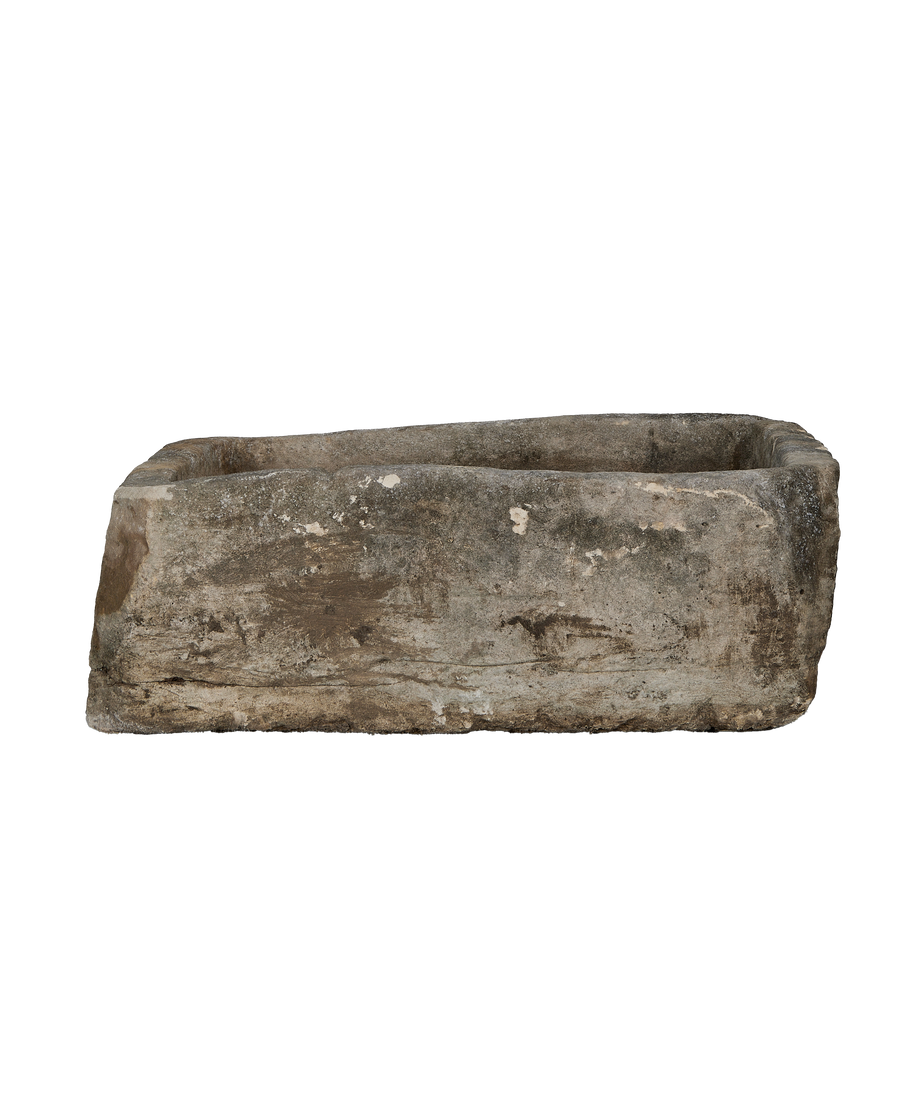 Vintage, rectangular Indonesian limestone trough with weathered, textured surface and worn edges, a side view.