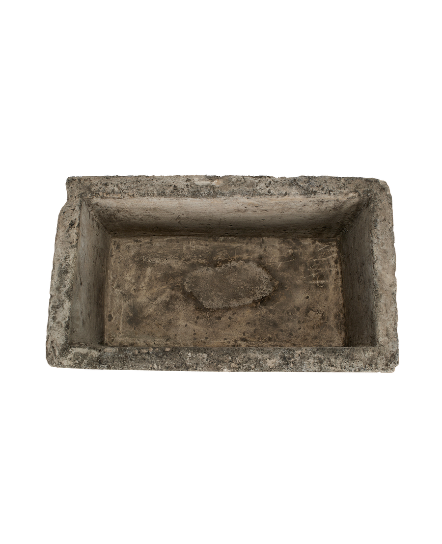 Vintage Indonesian limestone trough closeup, featuring rough-hewn rectangular edges and weathered interior surface.