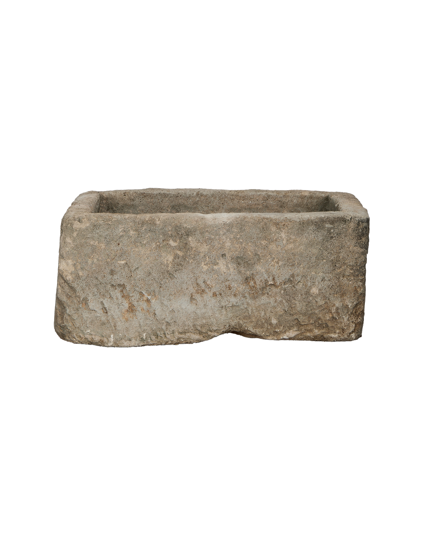 Vintage rectangular limestone trough, showing rough-hewn exterior texture and a worn surface.