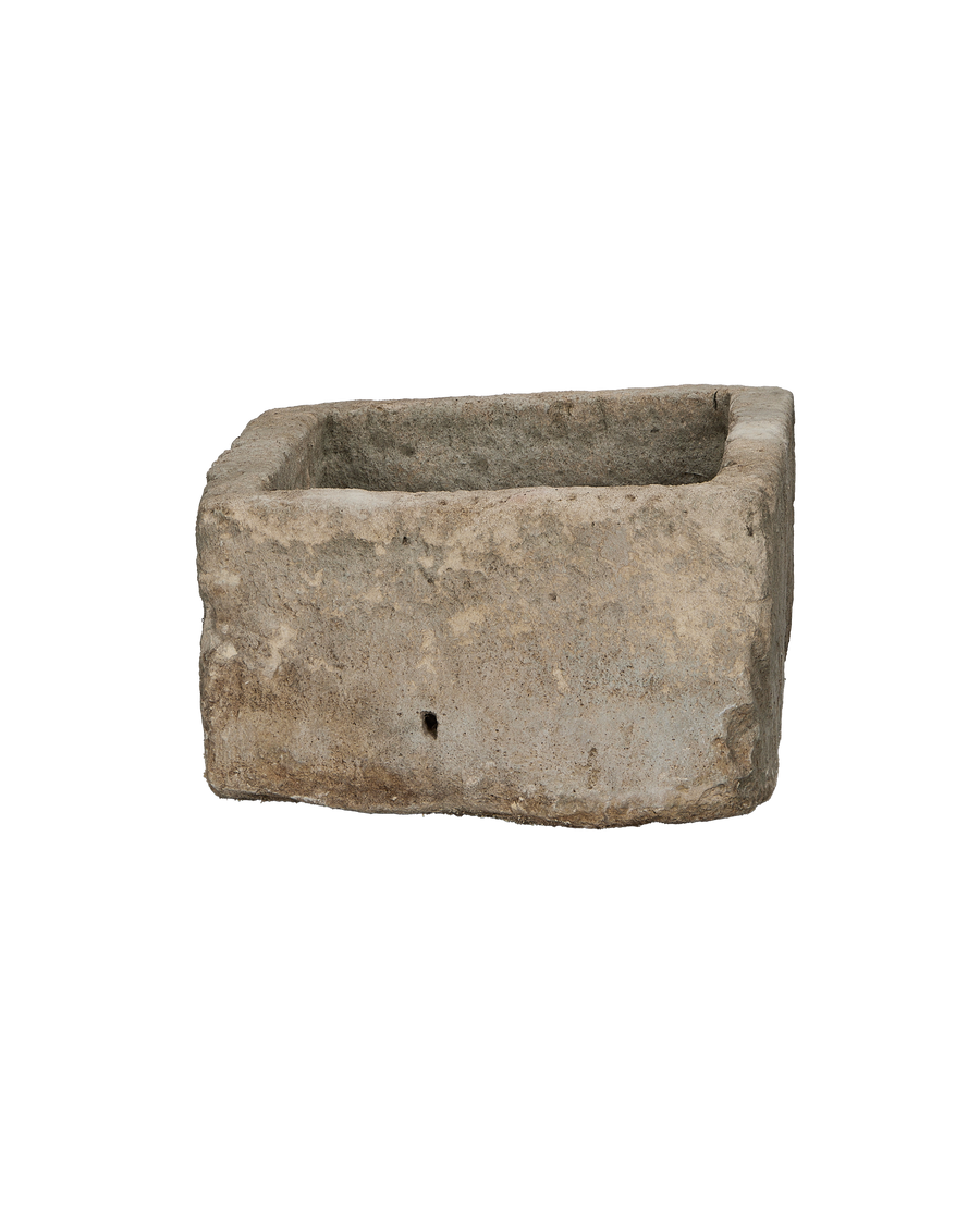 Vintage rectangular limestone trough, showing the side with a small natural drainage hole.
