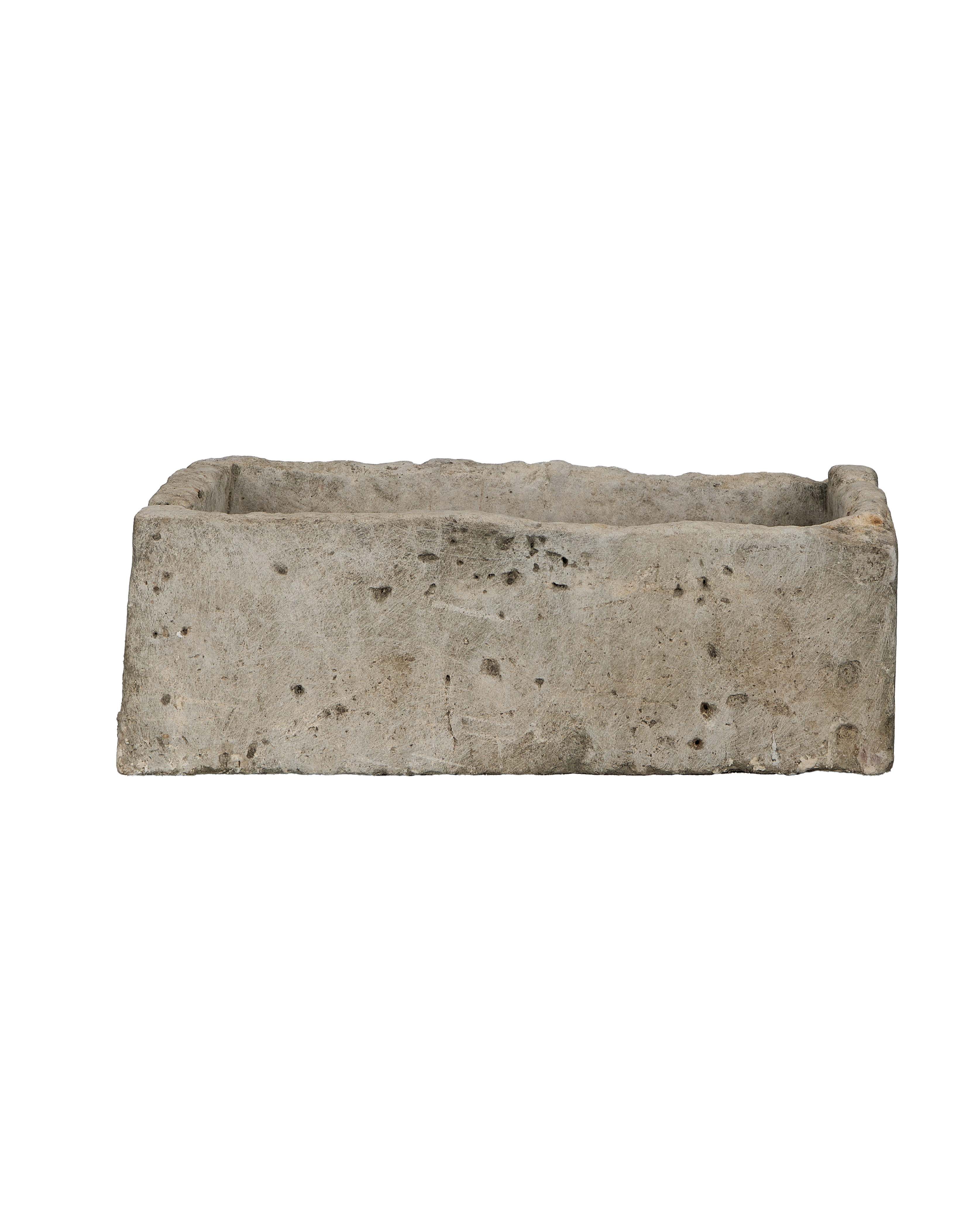 Vintage Indonesian rectangular limestone trough, showing rough textured exterior and weathered condition from side angle.