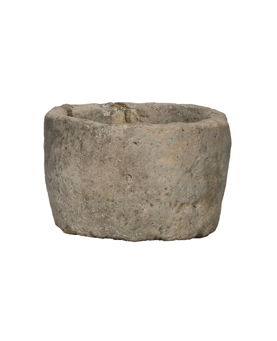 Side view of vintage round Indonesian limestone trough, showcasing textured exterior.