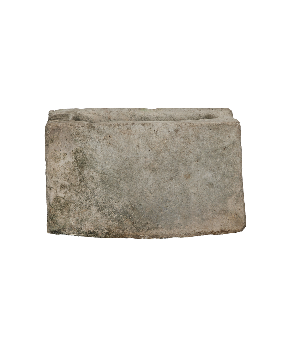 Vintage rectangular limestone trough, showing weathered texture with green moss and rough edges.