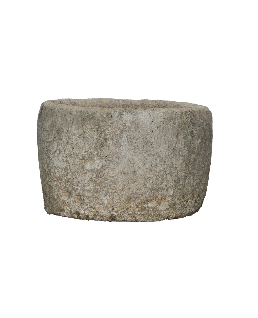Vintage round limestone trough, side view, showing weathered texture and natural imperfections.