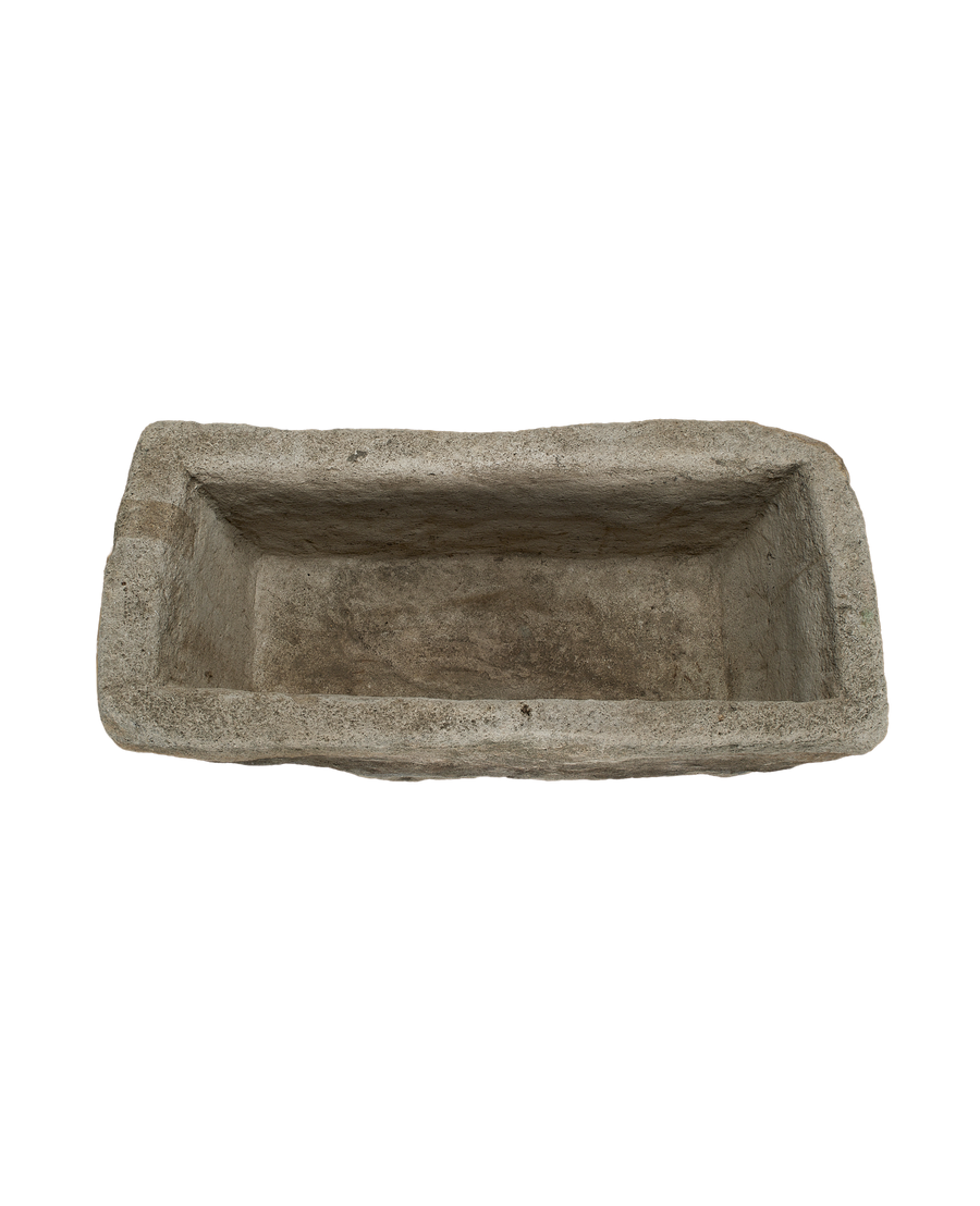 Vintage rectangular limestone trough, top view highlights weathered texture and aged interior.