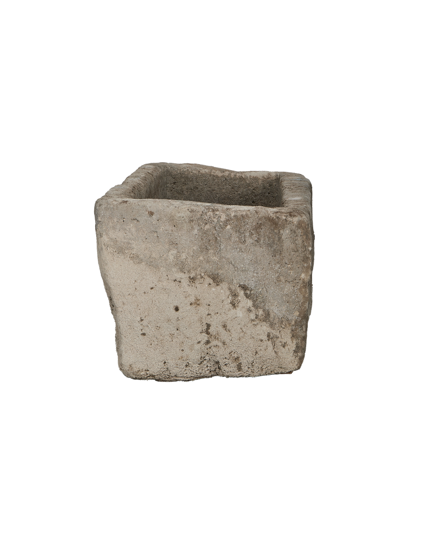 Vintage Indonesian limestone trough viewed from its side, highlighting rough texture and weathered surface.