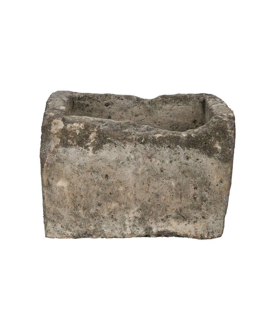 Vintage rectangular limestone trough, showing one side's weathered texture and natural imperfections.
